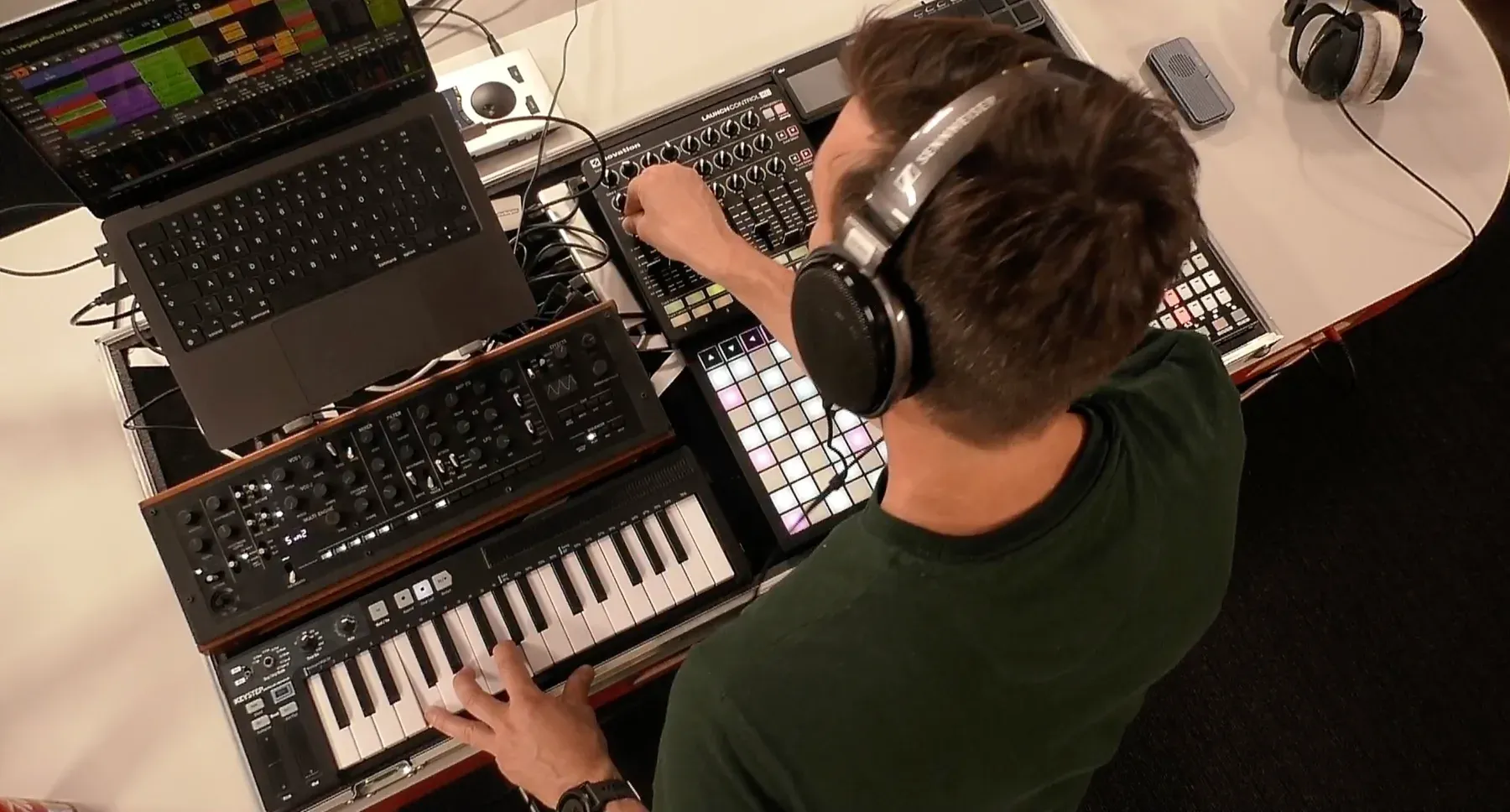 Overhead view of Creating Spaces performing live, one hand playing the synthesizer and the other adjusting the mixer.